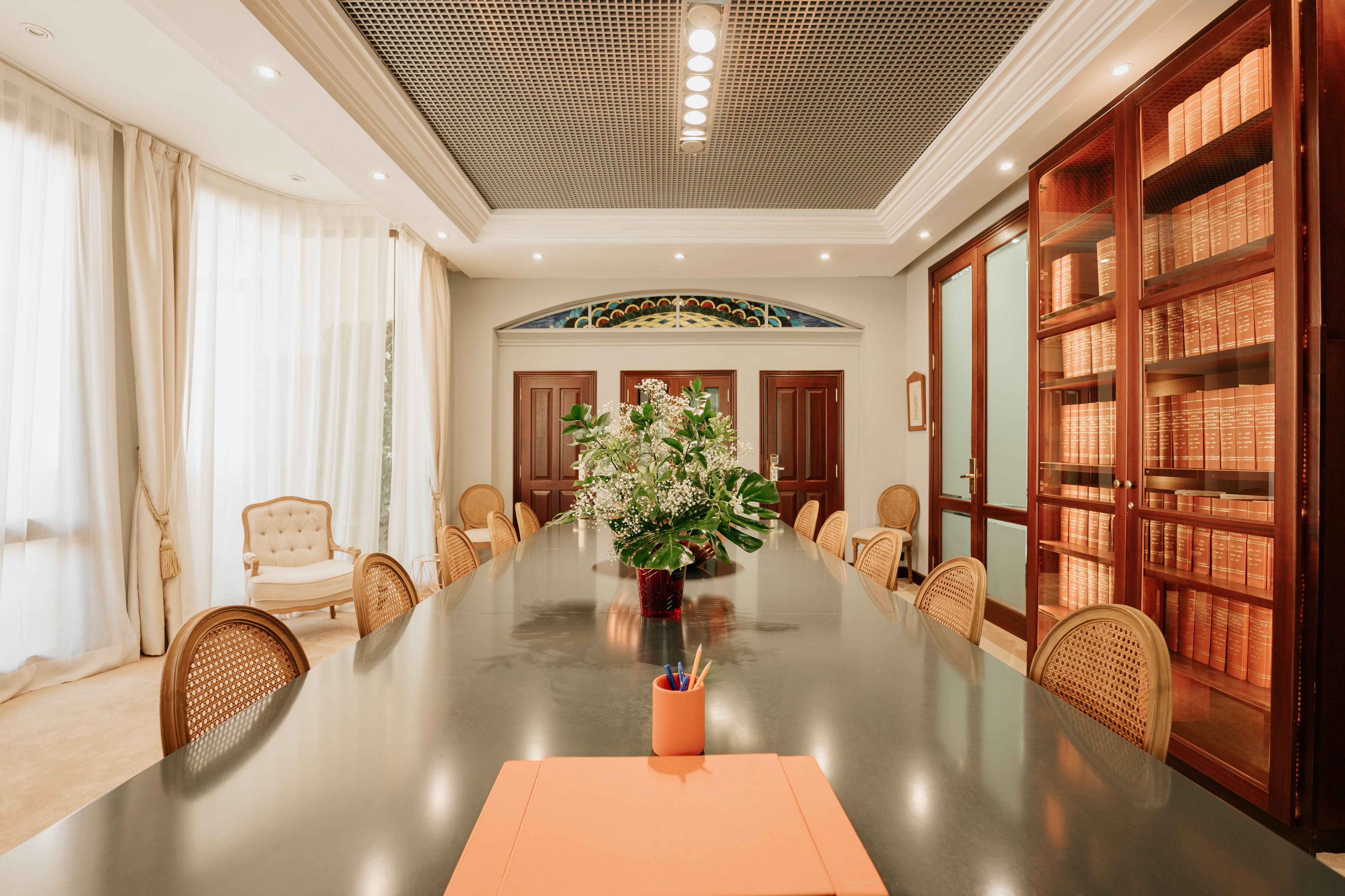 Sala de firmas real de la notaría, con mesa amplia y librería